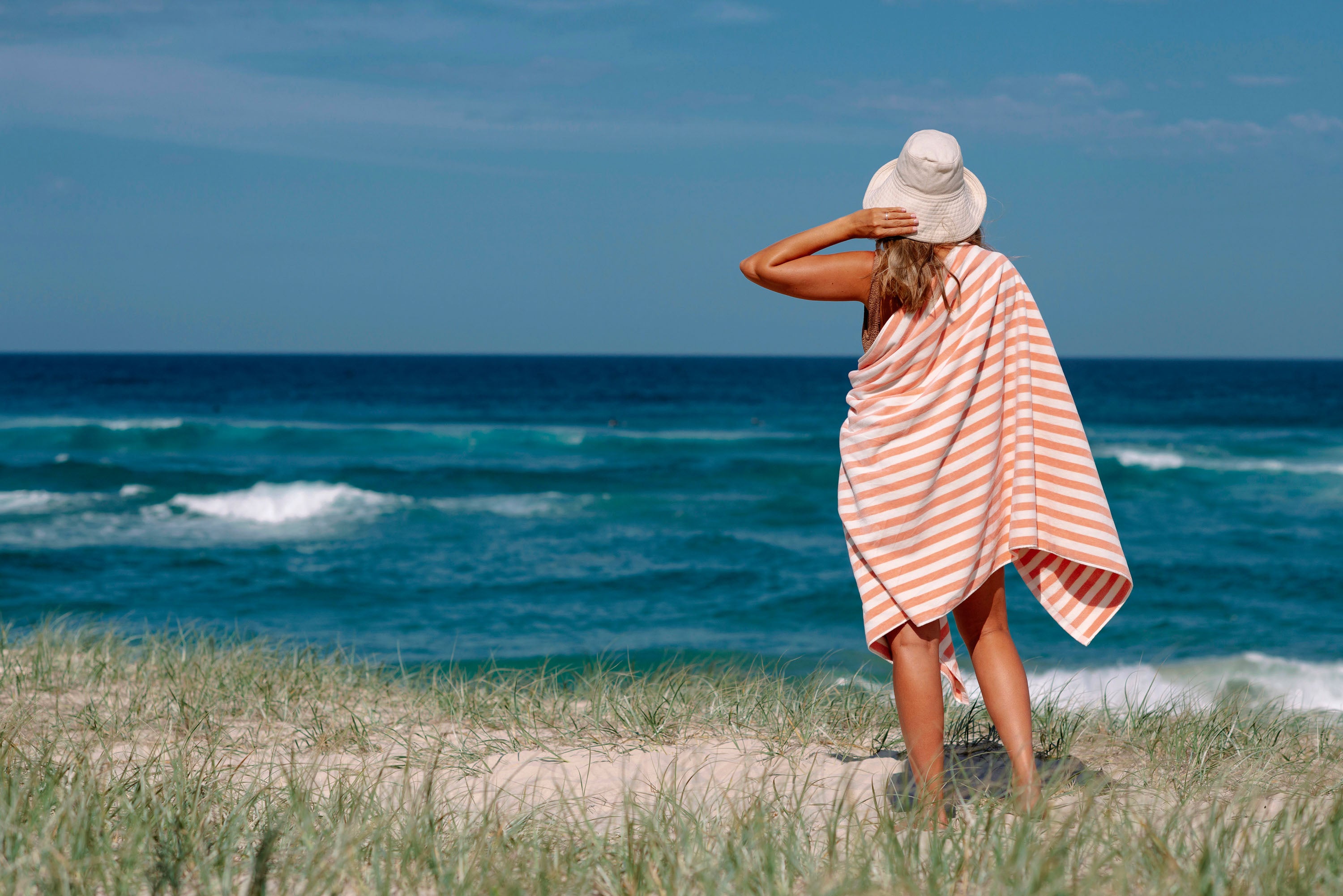 practising mindfulness looking at ocean with towel