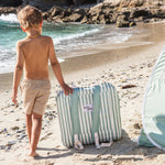 Child on a beach with a striped chair